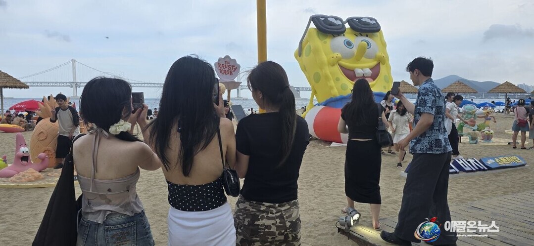 18일 부산시 수영구 광안리해수욕장에 설치된 대형 스폰지밥 캐릭터 포토존에서 시민과 관광객들이 기념사진을 촬영하며 여름 추억을 만들고 있다. (사진=이성애 기자)