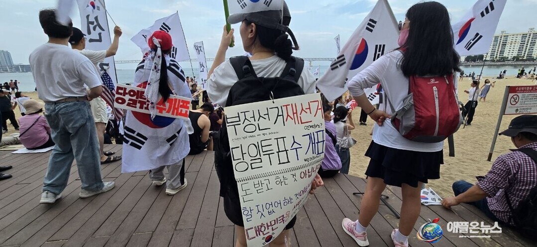 [애플온뉴스 부산=이성애 기자] 본격적인 여름 휴가철을 맞은 18일 부산시 수영구 광안리해수욕장을에 시민들이 &ldquo;부정투표 재선거 당일투표 수개표&rdquo;를 외치며 행진하고 있다.&nbsp;