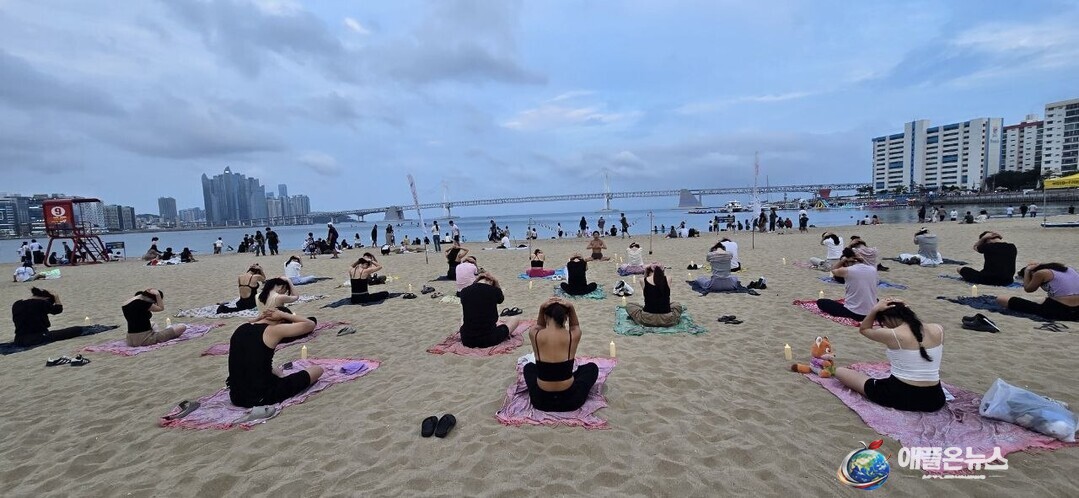 [애플온뉴스 부산=이성애 기자] 18일 부산 해운대구 광안리해수욕장 백사장에서 시민들이 해변 요가를 즐기고 있다. 광안리 앞바다를 배경으로 참가자들이 호흡을 가다듬으며 동작을 이어가고 있다.&nbsp;